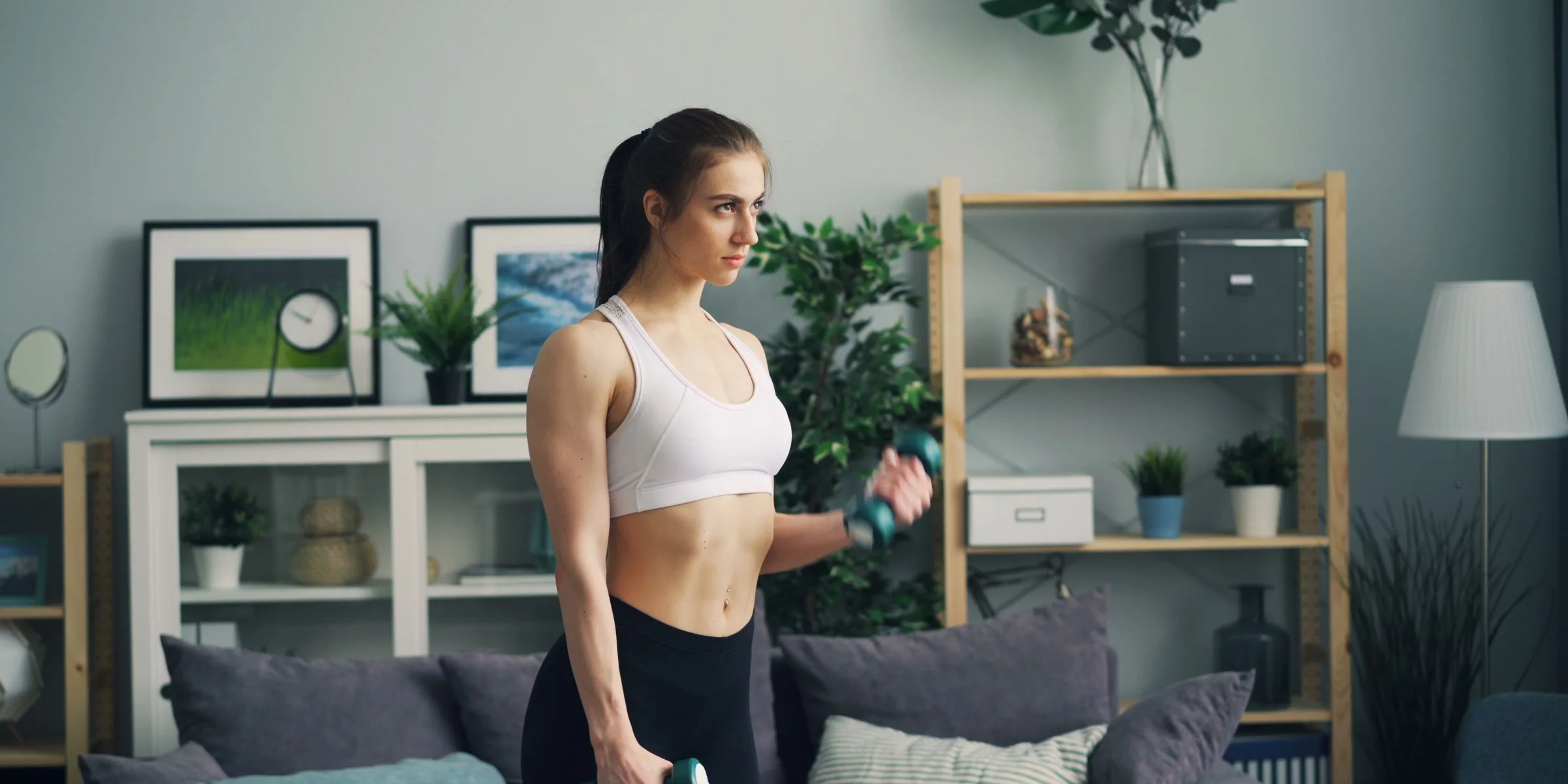 Woman training at home with dumbbells